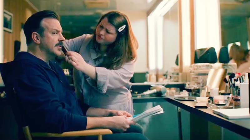 Jason Sudeikis sitting in makeup chair talking with make up artist