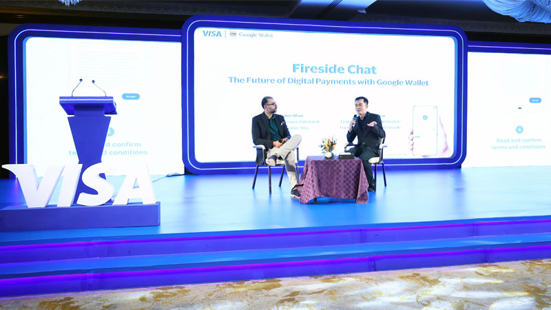 Visa and Google Wallet representatives sit on stage and take part in the conference