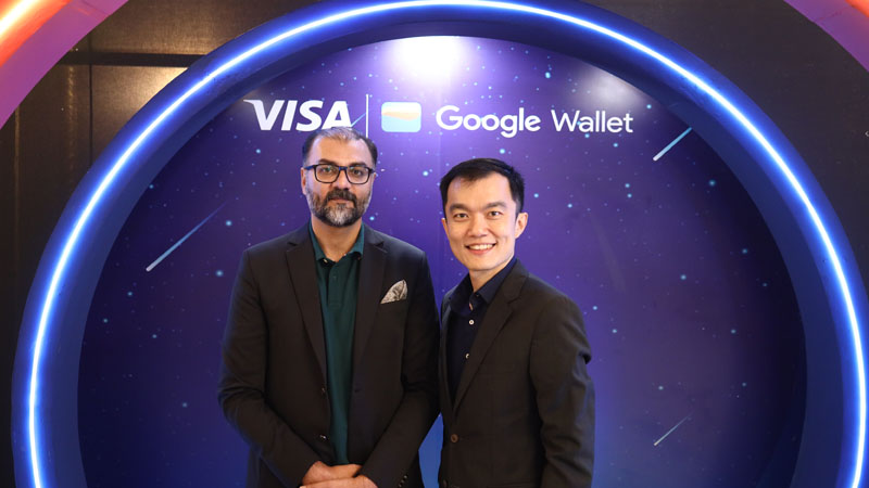 A representative of Visa and Google Wallet stands at the Visa and Google Wallet stand and looks directly at the camera