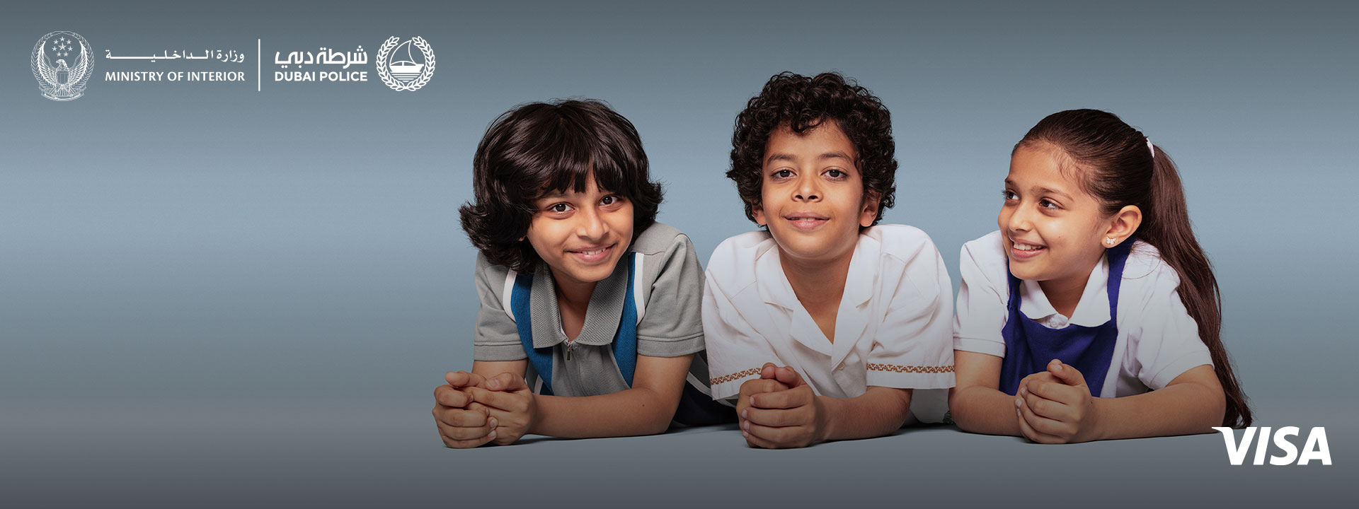 Two children look directly at the camera, one child looks at the two children